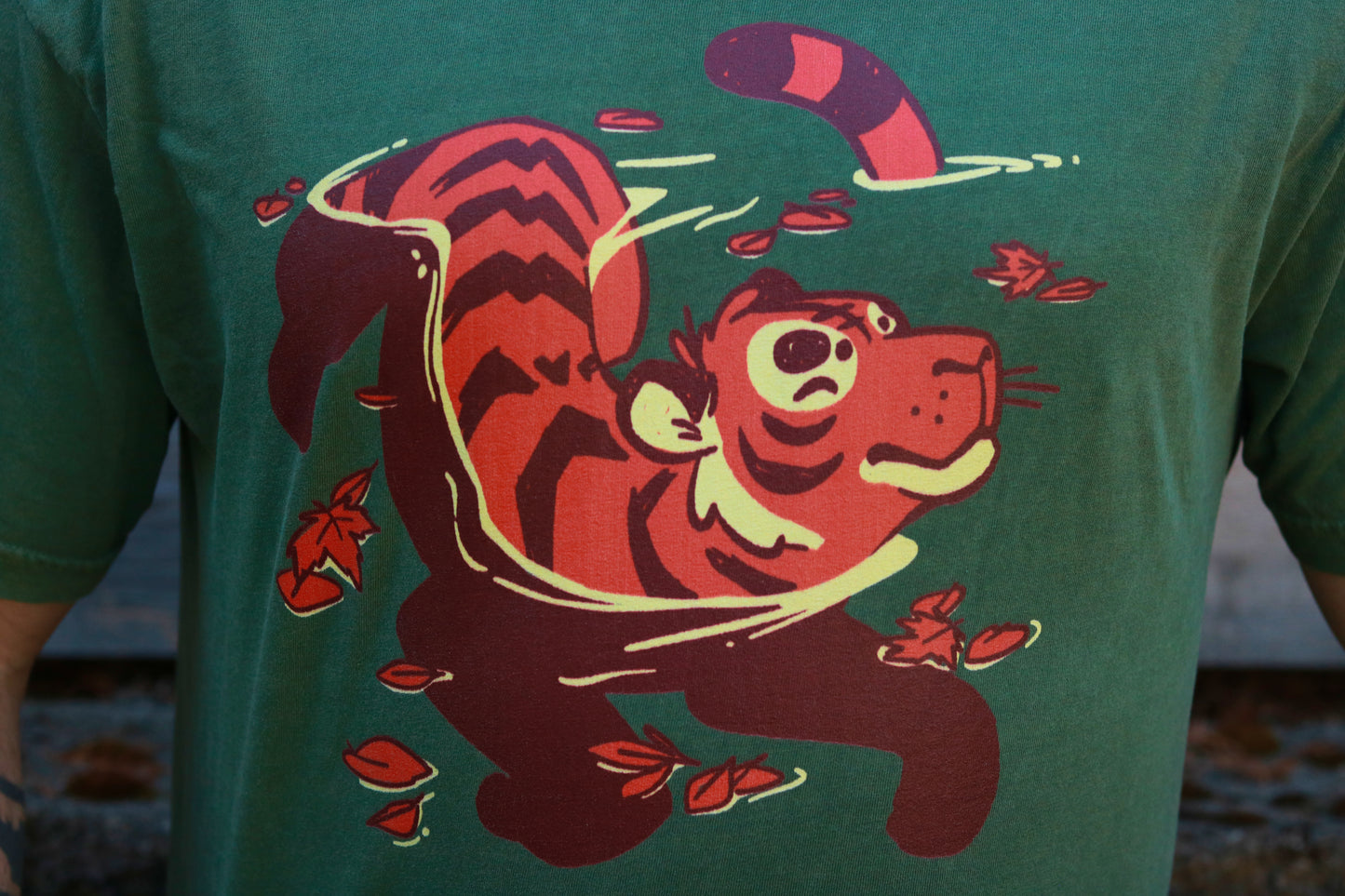 Green t-shirt with a red and black tiger graphic on a blurred background