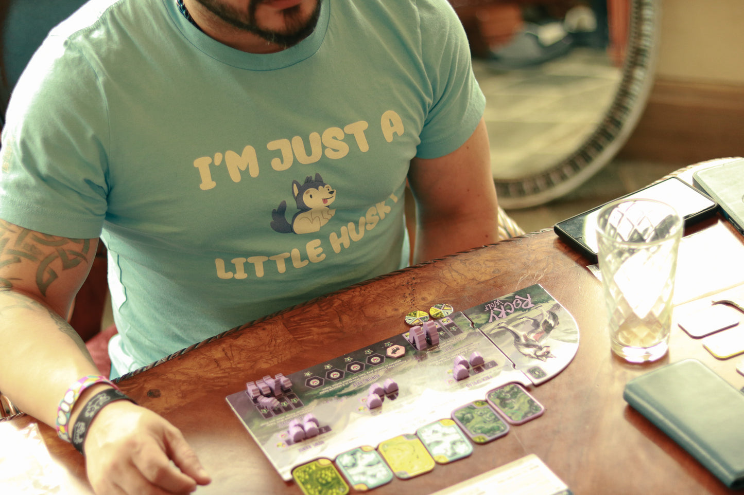 man with tattoos wearing tshirt featuring image of small husky and text "I'm just a little husky"