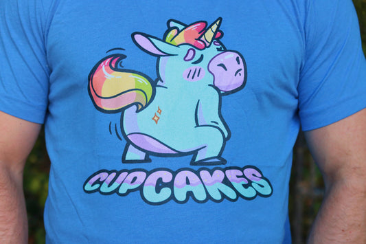 Blue t-shirt with a colorful unicorn graphic and 'CUPCAKES' text on a person wearing it.
