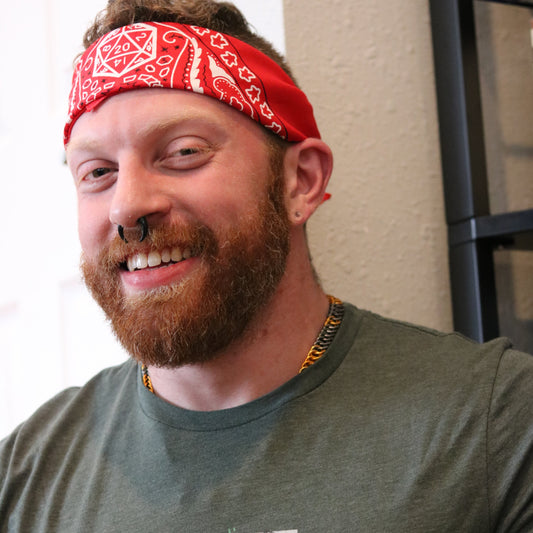 Ginger with nose ring and beard, wearing D20 dungeons and dragons themed bandana as a headband