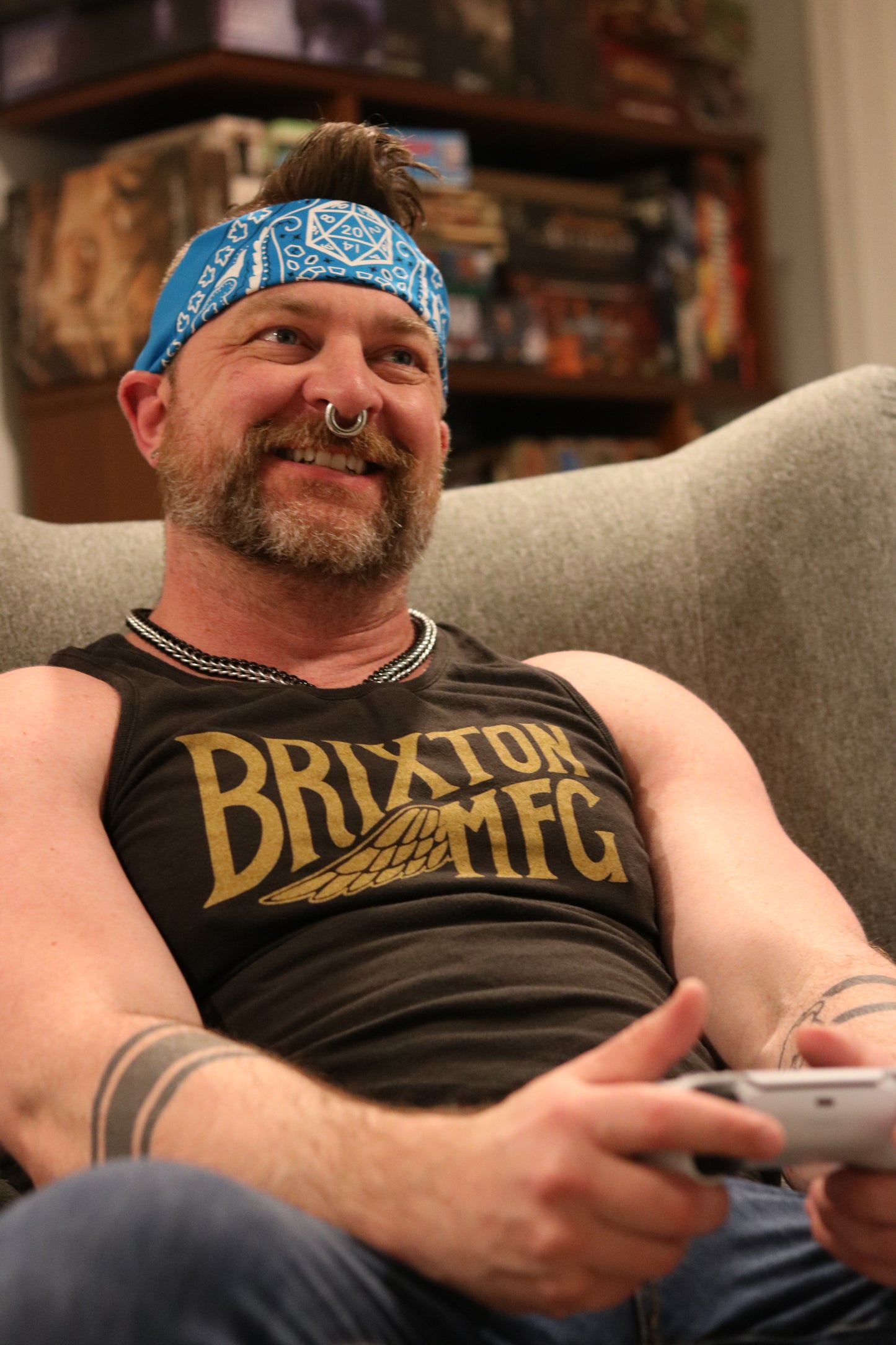 Brix, a handsome man with beard and nose ring, wearing a blue D20 dungeons and dragons themed bandana tied around his head