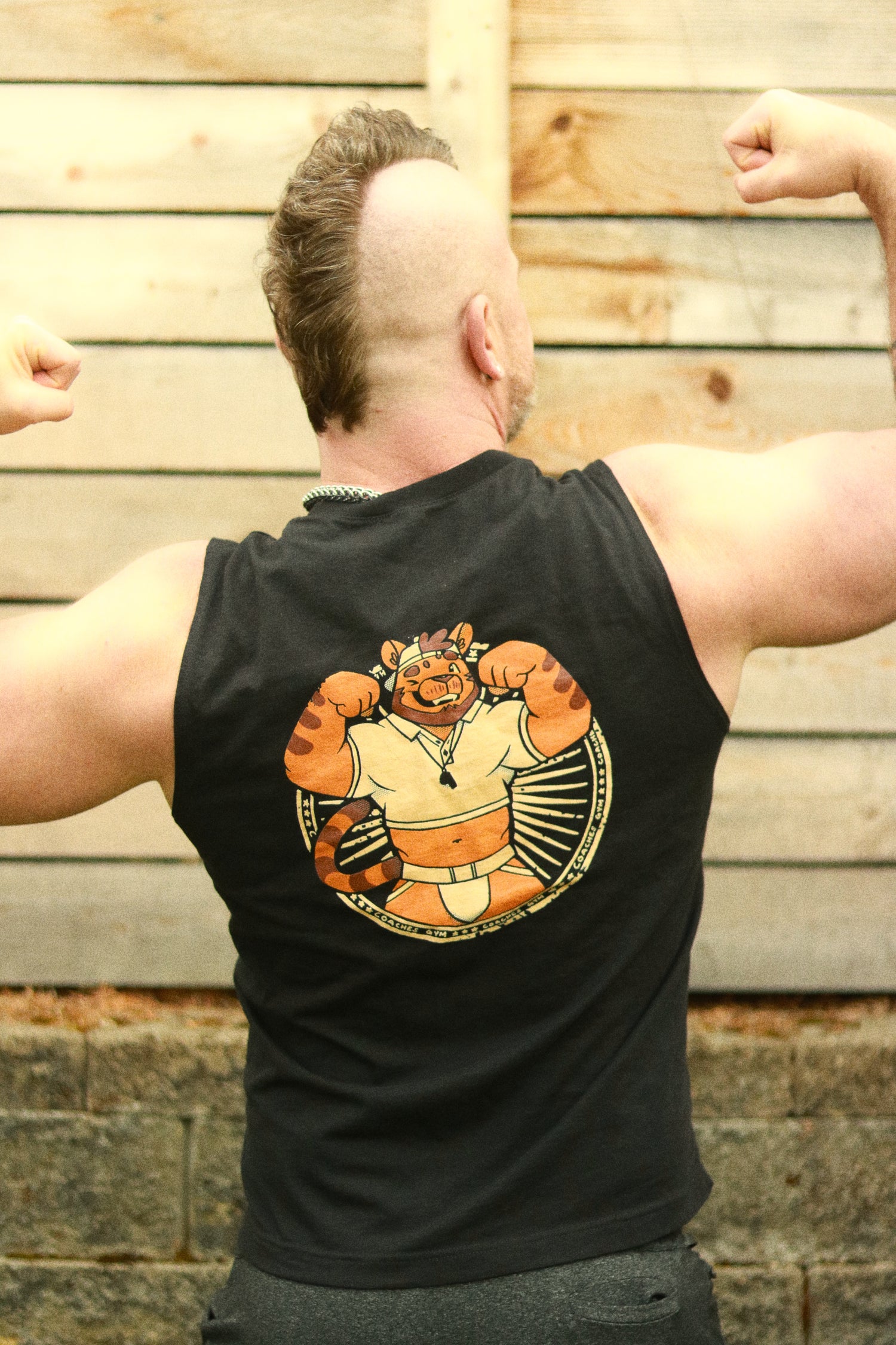 guy with mohawk flexing from behind wearing bolt-wear tank featuring flexing tiger coach